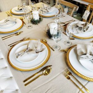 mesa posta com sousplat e talheres em dourado