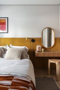 Cores pontuais em ambientes, nesse caso o amarelo na cabeceira, as cores transmitem uma energia e assim energia podem trazem harmonia e bem-estar.